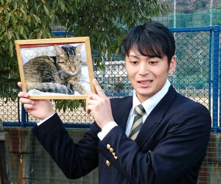 　愛猫「トラ」の写真を手に入寮した熊原