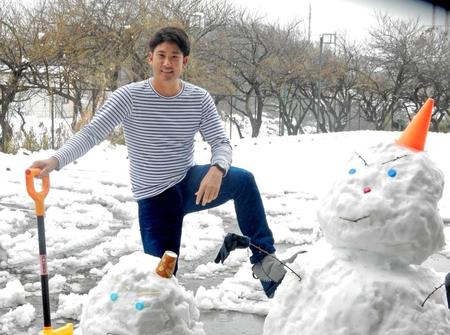 　雪だるまと記念撮影する菅野