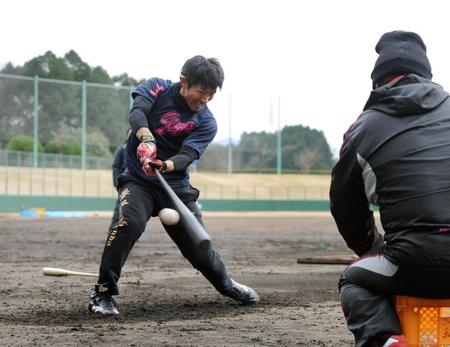 腰を低く落とした姿勢で打撃練習する本多