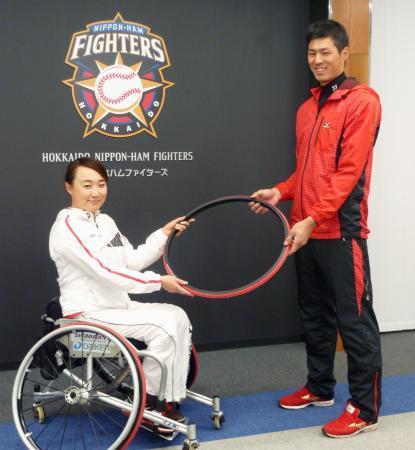 　車いすテニスの二條実穂選手（左）にタイヤセットを贈呈する日本ハムの岡＝２７日、千葉県鎌ケ谷市