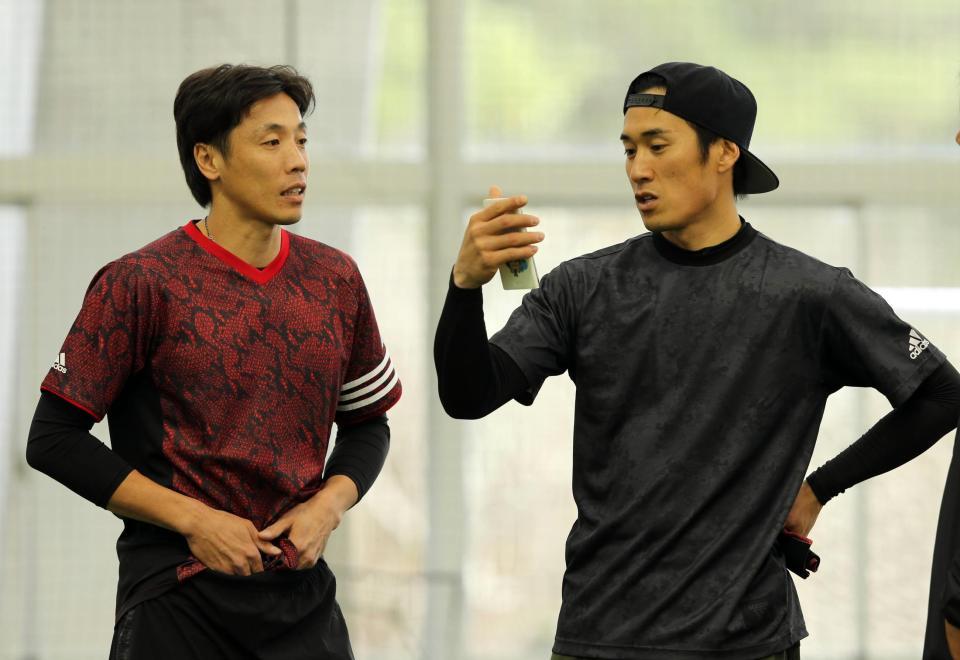 片岡（右）にスマホで撮った動画で走塁のアドバイスする鈴木（右）