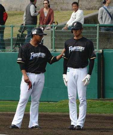 練習中、中田翔（左）に右腕をつかまれ直立不動になる日本ハム・大谷翔平＝名護（撮影・開出牧）