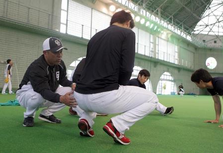 　捕手陣に捕球姿勢を指導する谷繁監督（左）＝北谷公園屋内運動場