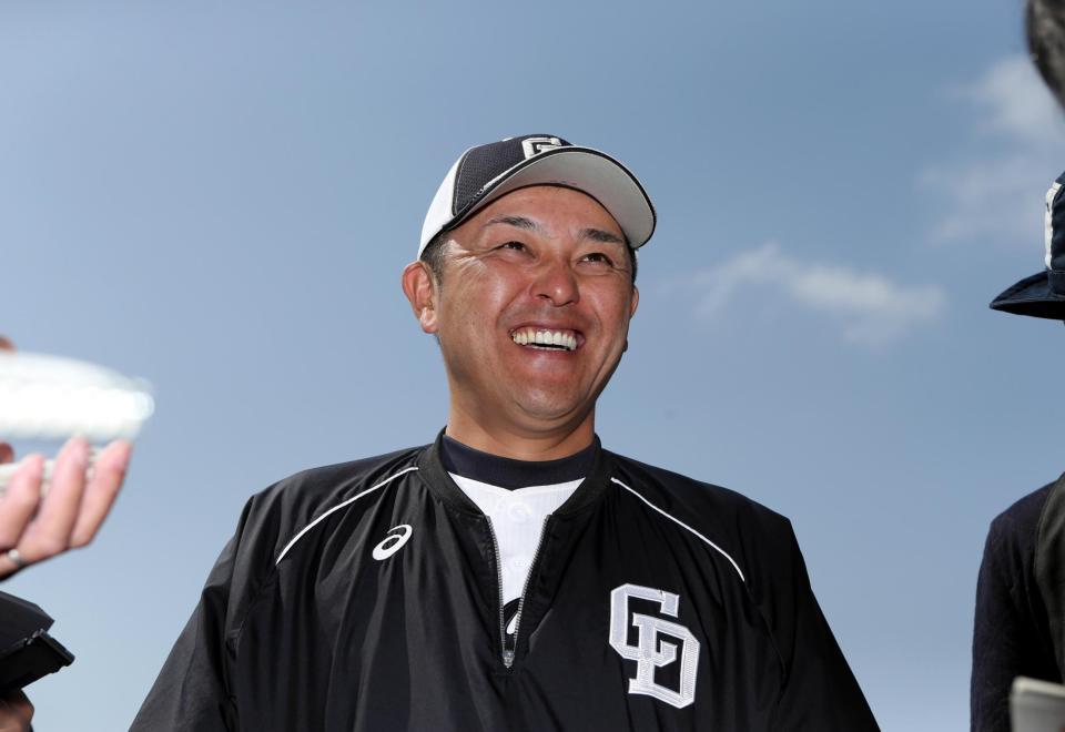 　澄みきった青空の下、笑顔で報道陣の質問に答える谷繁監督