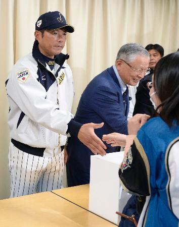 　台湾との強化試合前に行われた募金活動で、ファンと握手する日本代表の小久保監督（左）＝５日、ナゴヤドーム