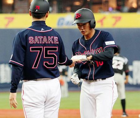 　７回、大城は左前打で出塁し、佐竹コーチ（左）とタッチを交わす