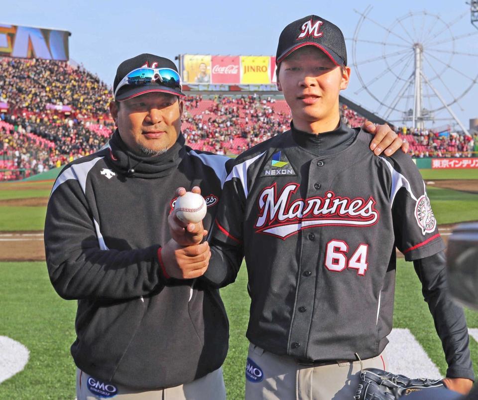 　完投でプロ初勝利を飾り、伊東監督（左）から祝福される二木