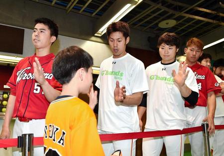 　熊本地震の募金を行いファンとタッチする立岡（中央）ら