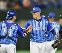 完封勝利を挙げ戸柱（左）と笑顔でタッチする井納（撮影・園田高夫）