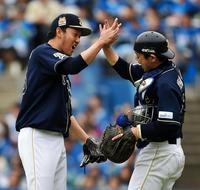 プロ通算１００セーブを挙げ、オリックス・山崎勝己とハイタッチを交わすオリックス・平野佳寿（左）＝ＱＶＣマリンフィールド（撮影・出月俊成）