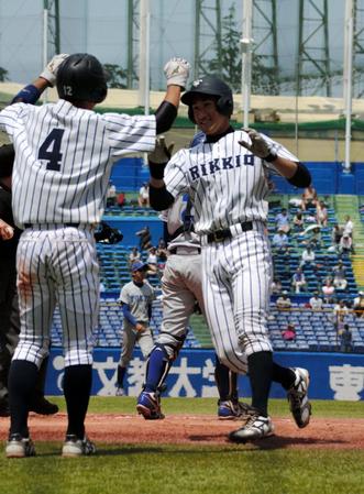 五回、左越え３ランを放って生還し、チームメートに迎えられる立大・佐藤