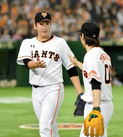 ６回、無失点に抑え、寺内崇幸とタッチする巨人・菅野智之（左）＝東京ドーム（撮影・西岡正）