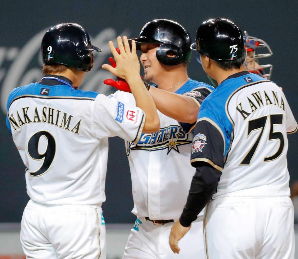 ６回、逆転満塁本塁打を放ち、中島（９）とタッチを交わす中田　