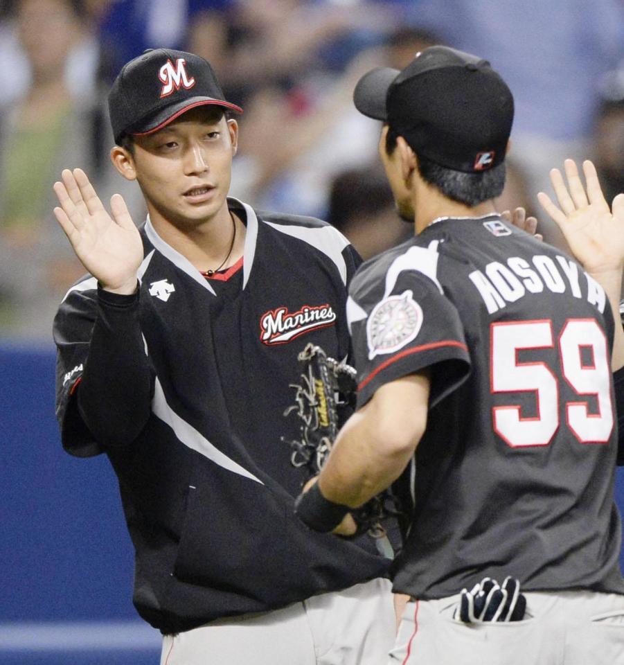 　中日に勝利し、タッチを交わすロッテ先発の関谷（左）と細谷＝ナゴヤドーム