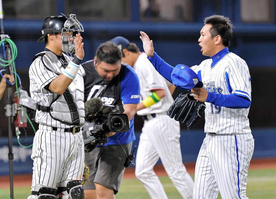 　９回を無失点に抑えた山崎康（右）は原口とタッチを交わす