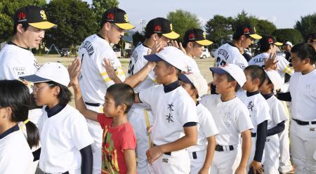 　熊本県益城町の小学校を訪れ、少年野球チームの子どもたちとタッチを交わすソフトバンクの（左から）五十嵐選手、内川選手ら＝２１日午後