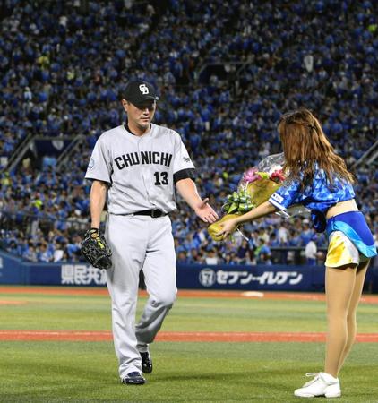 ８回に中日・岩瀬が通算９００試合登板を果たしすも３失点で逆転を許し、沈んだ表情で花束を受け取る＝横浜スタジアム