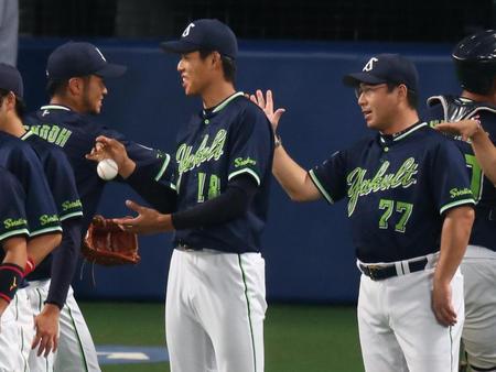 ナインを迎える勝利投手の杉浦と真中監督（右）