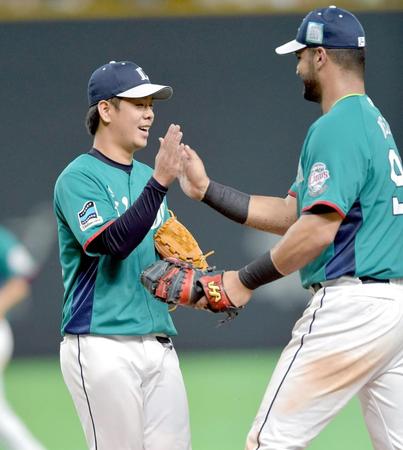 最後の打者・大谷を一ゴロに仕留め完封勝利。メヒアと笑顔でタッチを交わす多和田（左）