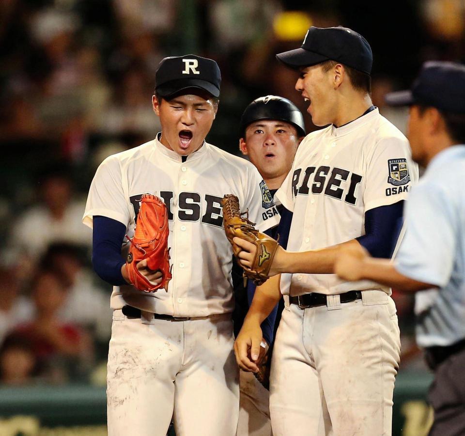 横浜相手に完投勝利の寺島（左）はナインとグラブタッチを交わす＝甲子園