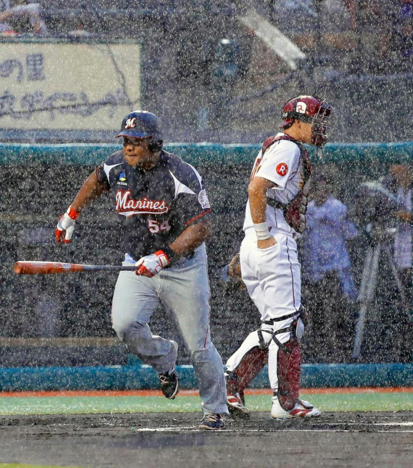 　１回、激しい雨で試合が中断し、ベンチに戻るデスパイネ（左）と捕手・足立。この後、降雨ノーゲームとなる