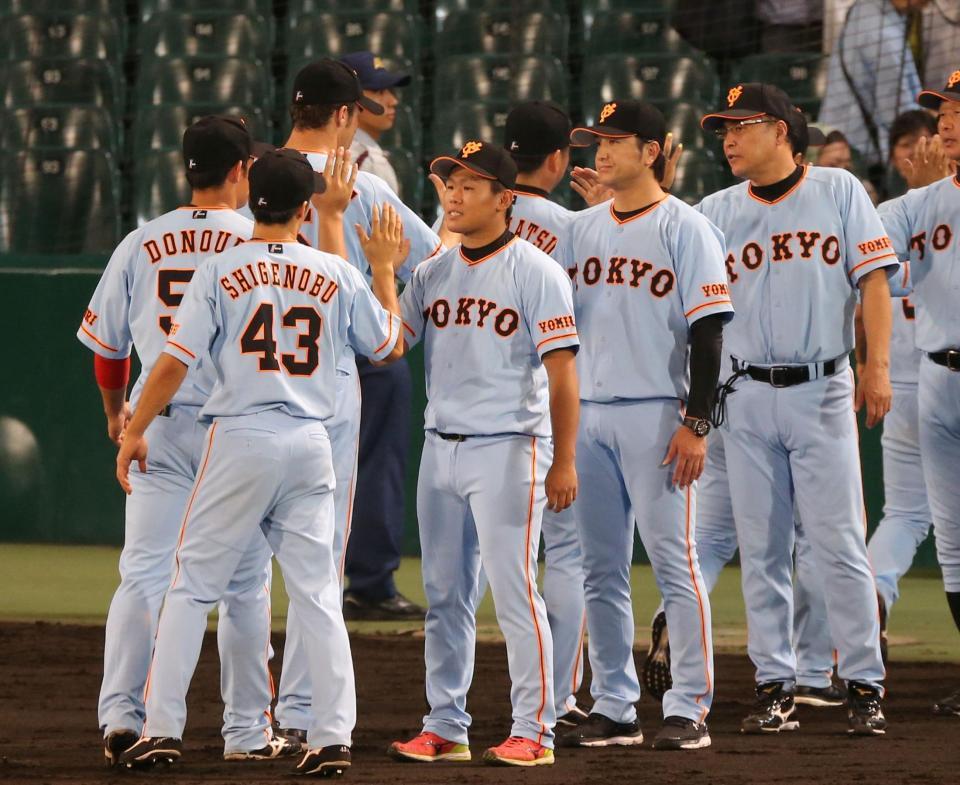 ハイタッチでナインを迎える巨人・田口麗斗ら巨人ナイン＝甲子園（撮影・飯室逸平）