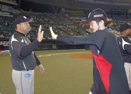 　１３勝目を挙げた石川（右）とタッチをかわすロッテ・伊東監督