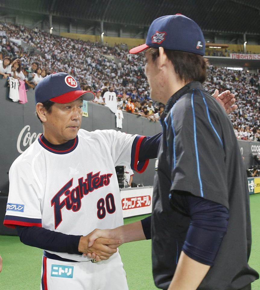 　10勝目を挙げた高梨（右）と握手を交わす日本ハム・栗山監督＝札幌ドーム