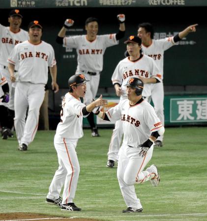 　１０回、サヨナラ満塁本塁打を放ち、巨人ナインが大喜びする中、ベースを回る村田（手前右）