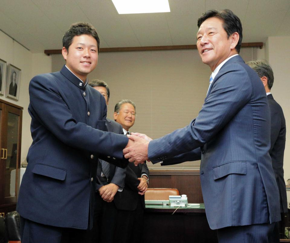 　指名あいさつに訪れた栗山監督（右）と握手を交わす広島新庄・堀