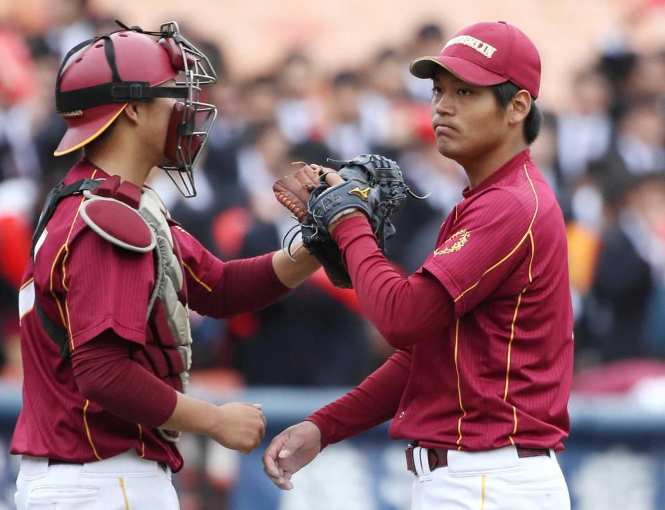 　中央学院大戦で完投勝利を挙げ、大平（左）とタッチを交わす桜美林大・佐々木千