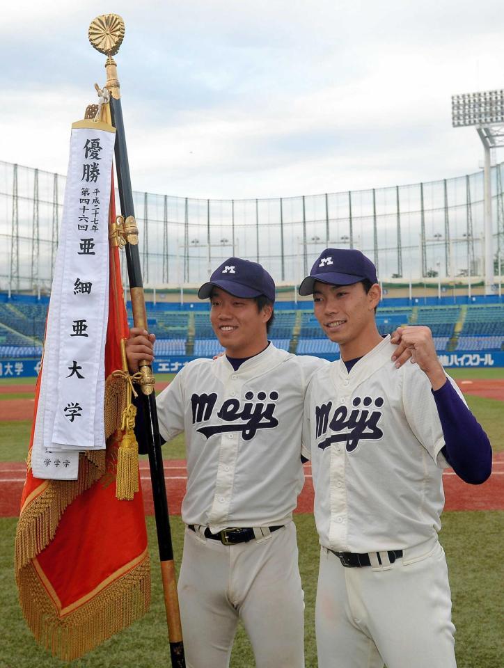 　優勝旗を手に笑顔の明大・柳と星（右）