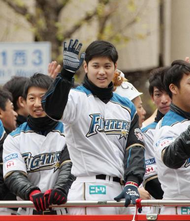 　優勝パレードに集まった沿道のファンに手を振る日本ハム・大谷翔平選手＝20日午前、札幌市