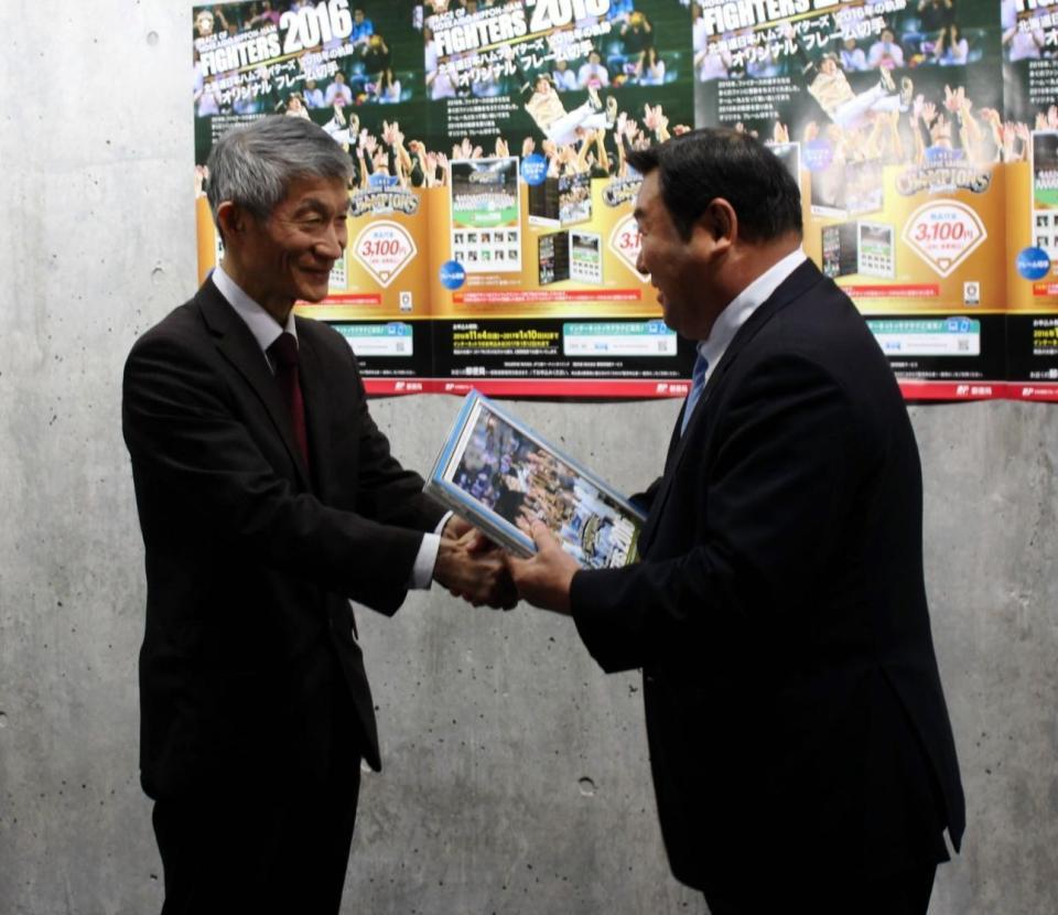 日本郵便関係者から記念切手フレームの贈呈を受ける日本ハム・竹田球団社長