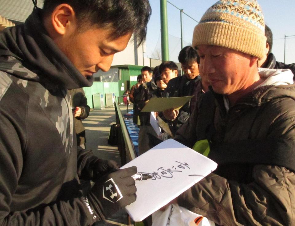 練習後に行われた即席サイン会でペンを走らせる巨人のドラフト１位吉川尚（左）