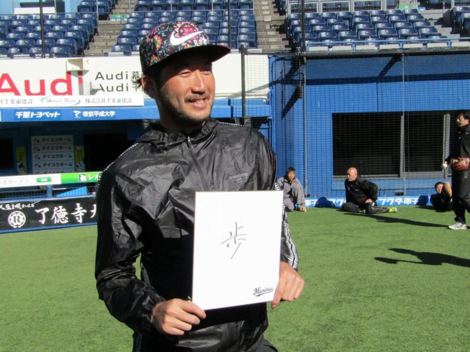 　「歩」と書いた色紙を手に、抱負を語る石川