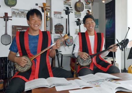 　キャンプ初の休日で、沖縄伝統の弦楽器、三線の演奏に挑戦した中日の柳（左）と京田＝沖縄県読谷村