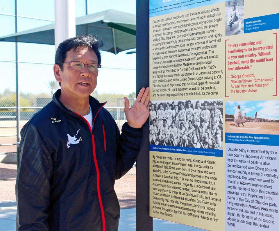 　日系人野球の父・銭村健一郎氏の功績が記された看板の前に立つ栗山監督