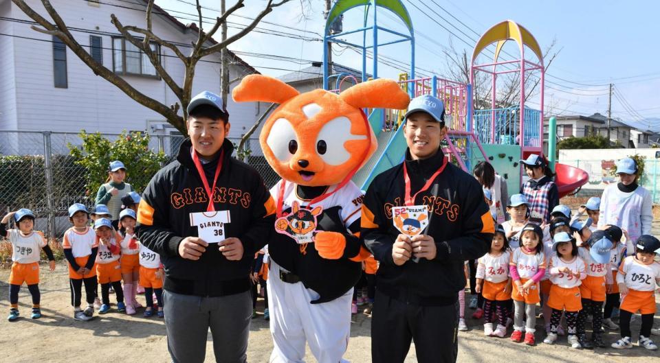 　園児からプレゼントされたメダルをかけ笑顔を見せる巨人の岡本（左）と宇佐見＝木花幼稚園