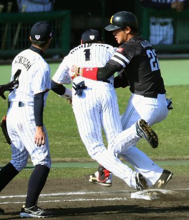 　８回、打者走者のソフトバンク・斐紹（右）と交錯して倒れる日本の一塁手内川（１）。この後負傷退場した＝宮崎
