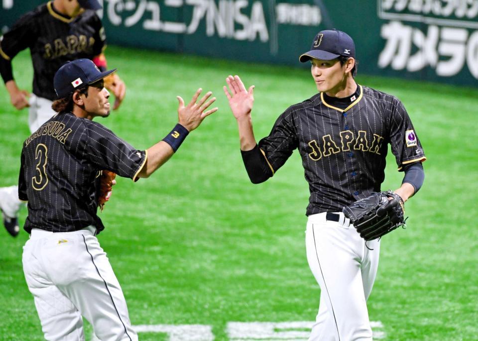 　８回、１イニングを無失点に抑えて松田（左）とタッチを交わす藤浪（撮影・棚橋慶太）
