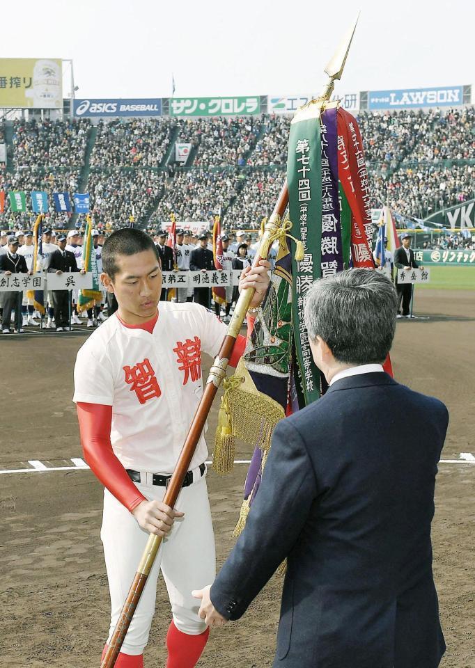 　第89回選抜高校野球大会の開会式で優勝旗を返還する智弁学園の福元悠真主将＝19日午前、甲子園球場（代表撮影）