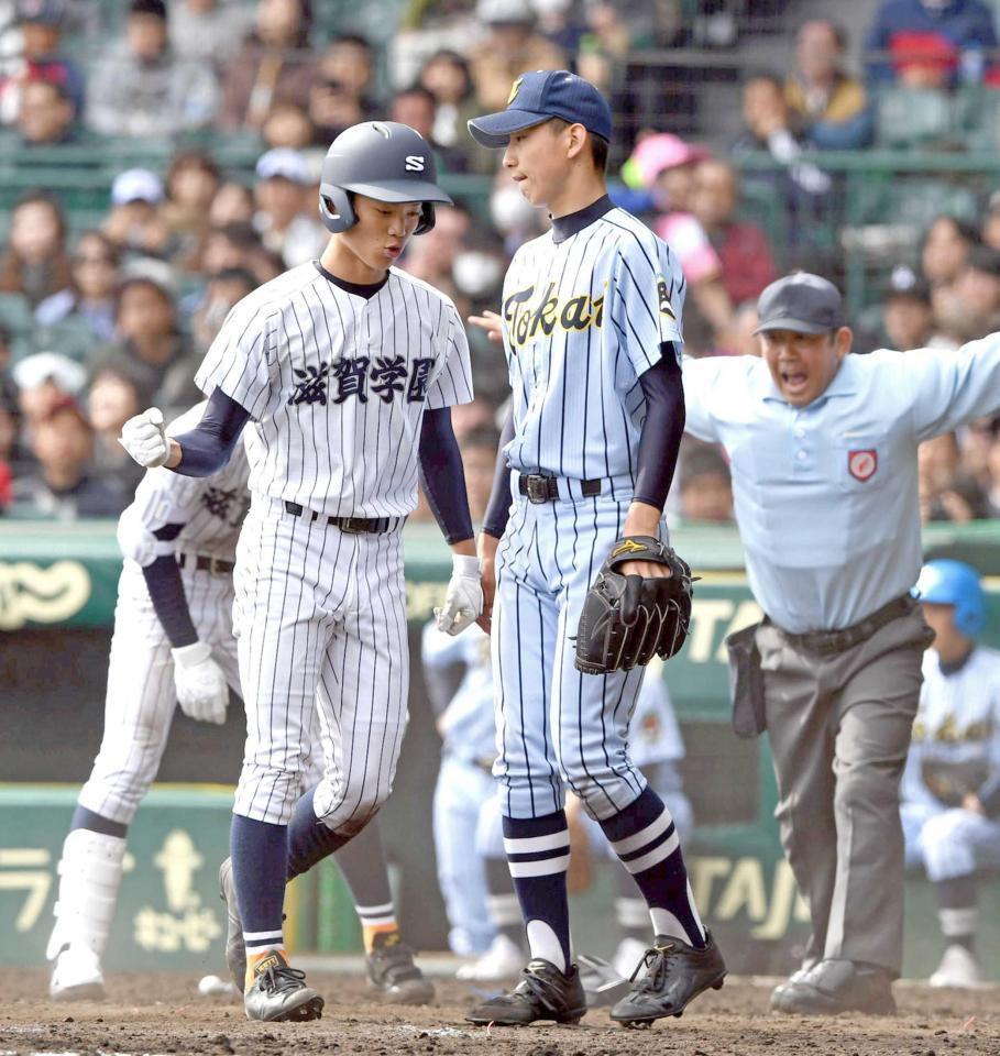 　延長１４回、滋賀学園・真藤の適時打で生還しガッツポーズする棚原（左）。右は東海大市原望洋・金久保（撮影・山口登）