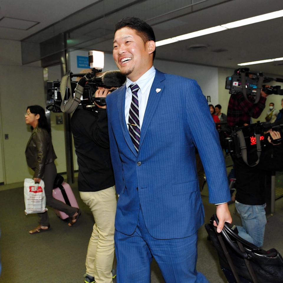 　帰国して笑顔を見せる筒香＝成田空港