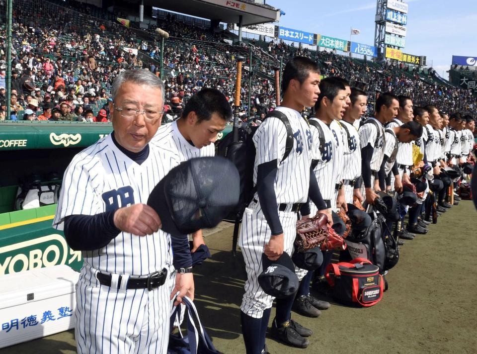 初戦敗退し厳しい表情で甲子園を去る馬淵監督（左）ら明徳義塾ナイン（撮影・山口登）