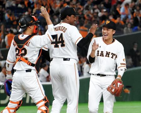 開幕戦を勝利で飾りタッチをかわすカミネロと坂本（右）＝東京ドーム（撮影・堀内翔）