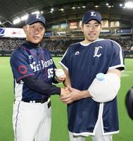 　ウイニングボールを手に辻監督（左）と握手する西武・菊池＝札幌ドーム