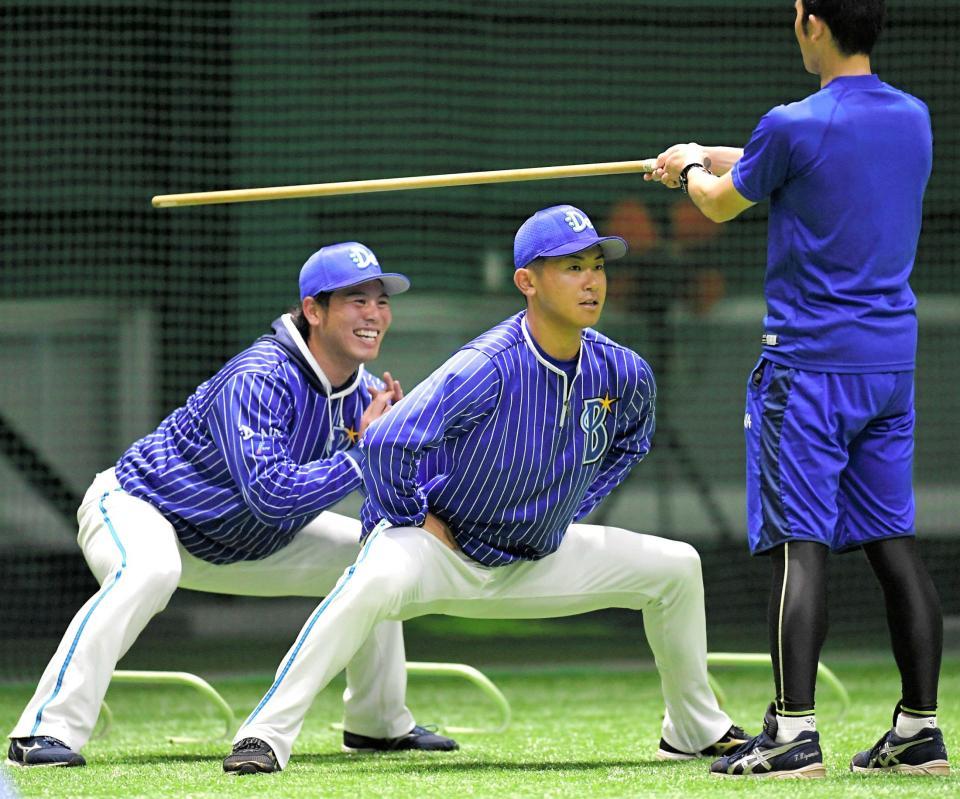 　２人そろって棒の下をくぐり抜ける今永と浜口（奥）