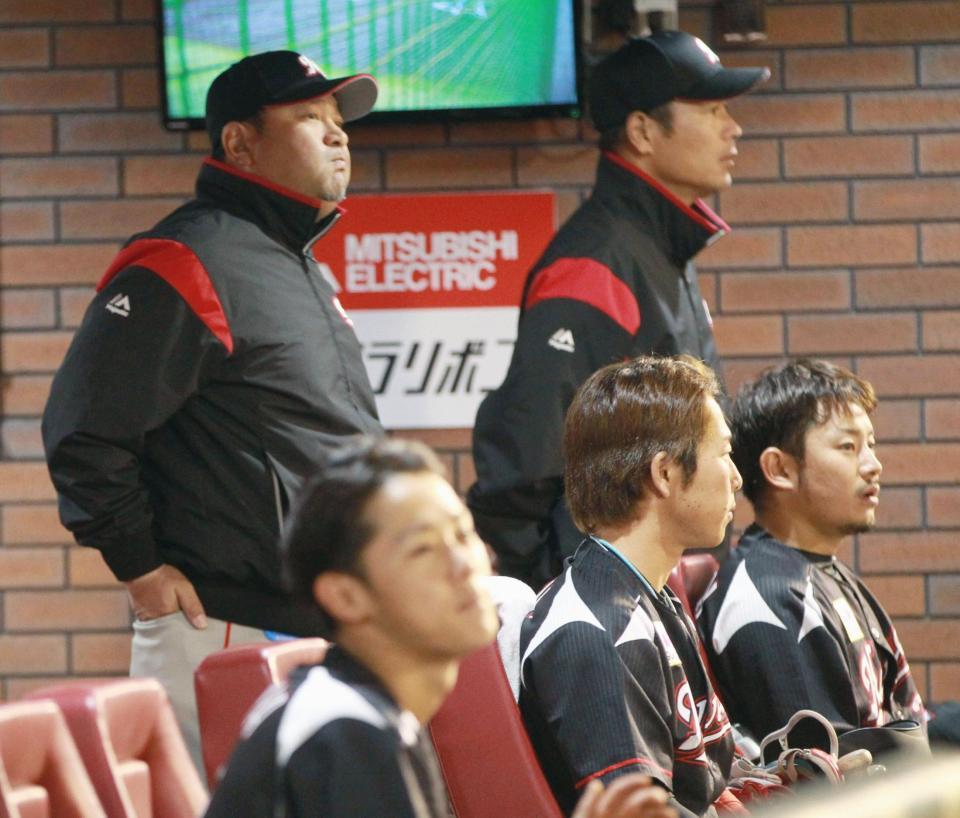 　９回の攻撃中、さえない表情で試合を見つめるロッテの伊東監督（奥左）ら＝Ｋｏｂｏパーク宮城