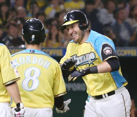 　３回、４打数連続本塁打のプロ野球記録に並ぶ２ランを放ち、近藤（左）に迎えられる日本ハムのレアード＝東京ドーム